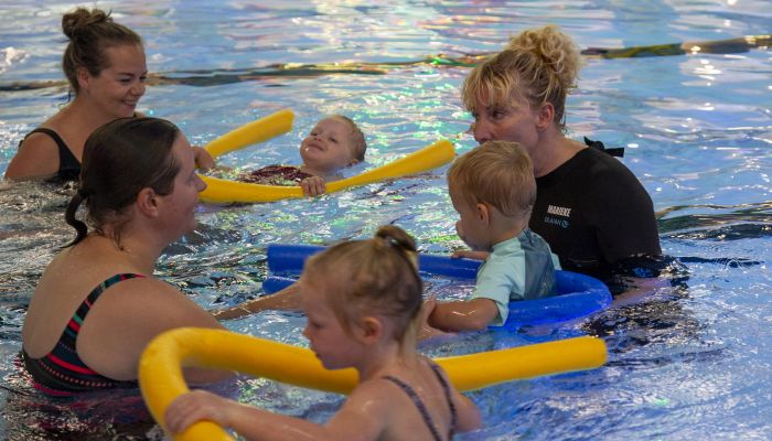 Zweminstructrice geeft les aan 2 moeders en 3 kinderen met Ouder & Kind zwemmen